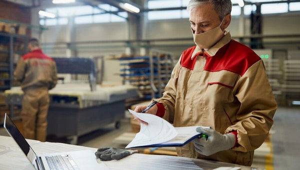 Hombre consultando factura de la luz en una fábrica