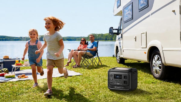Familia disfrutando camping junto a autocaravana y BLUETTI
